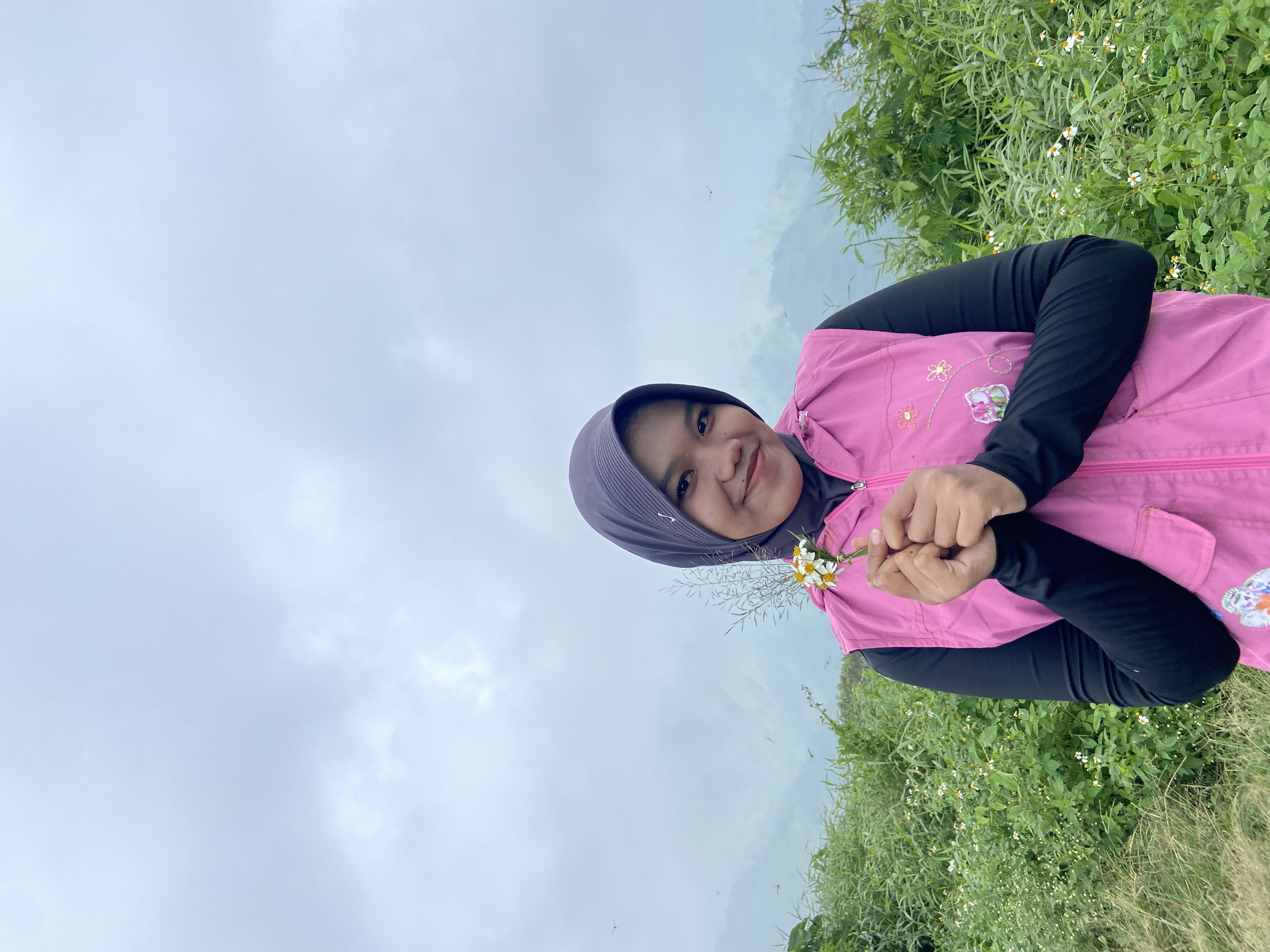 Nabila di padang bunga dengan langit biru