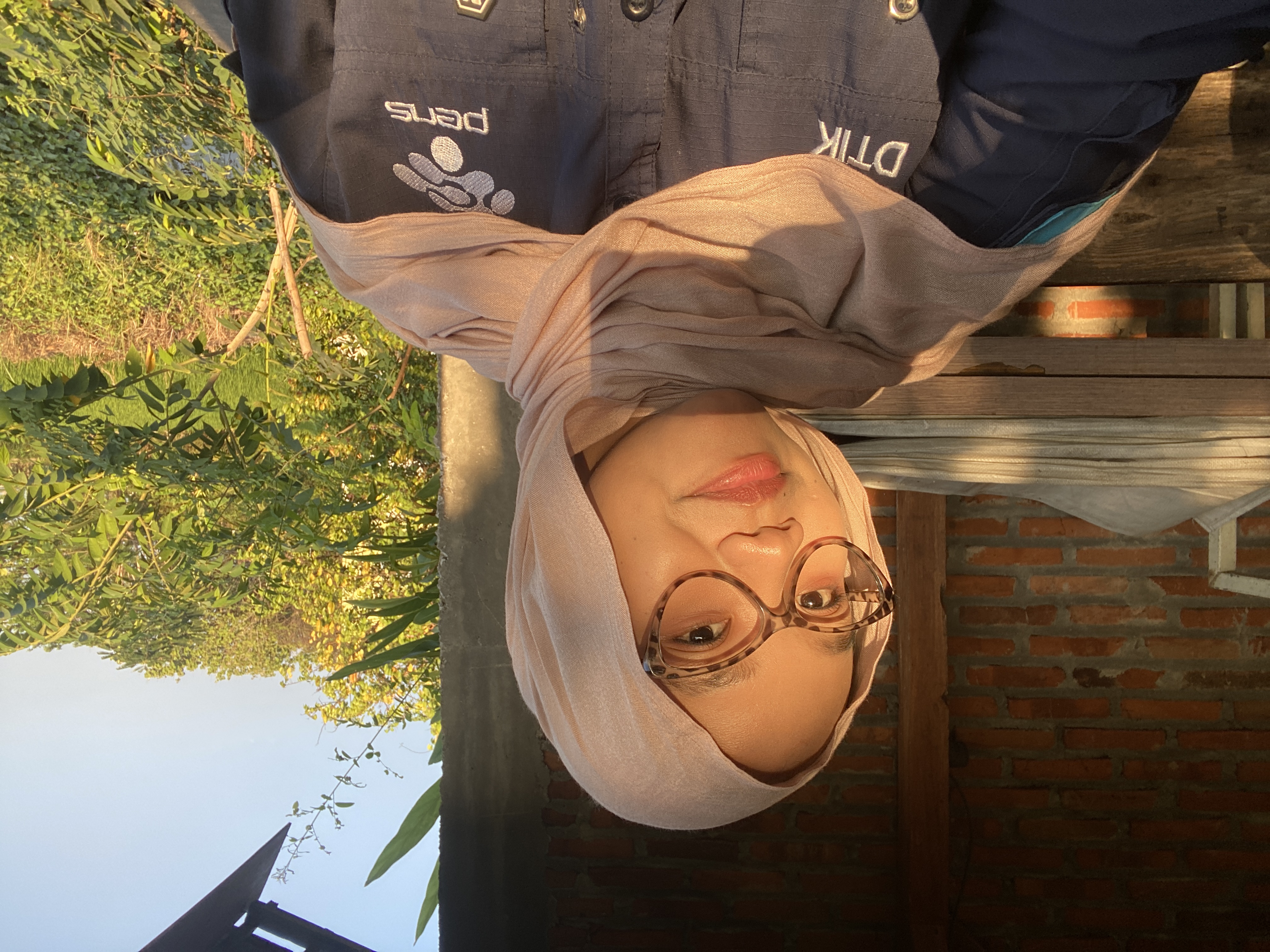 Nabila mengenakan kacamata di bawah cahaya sore