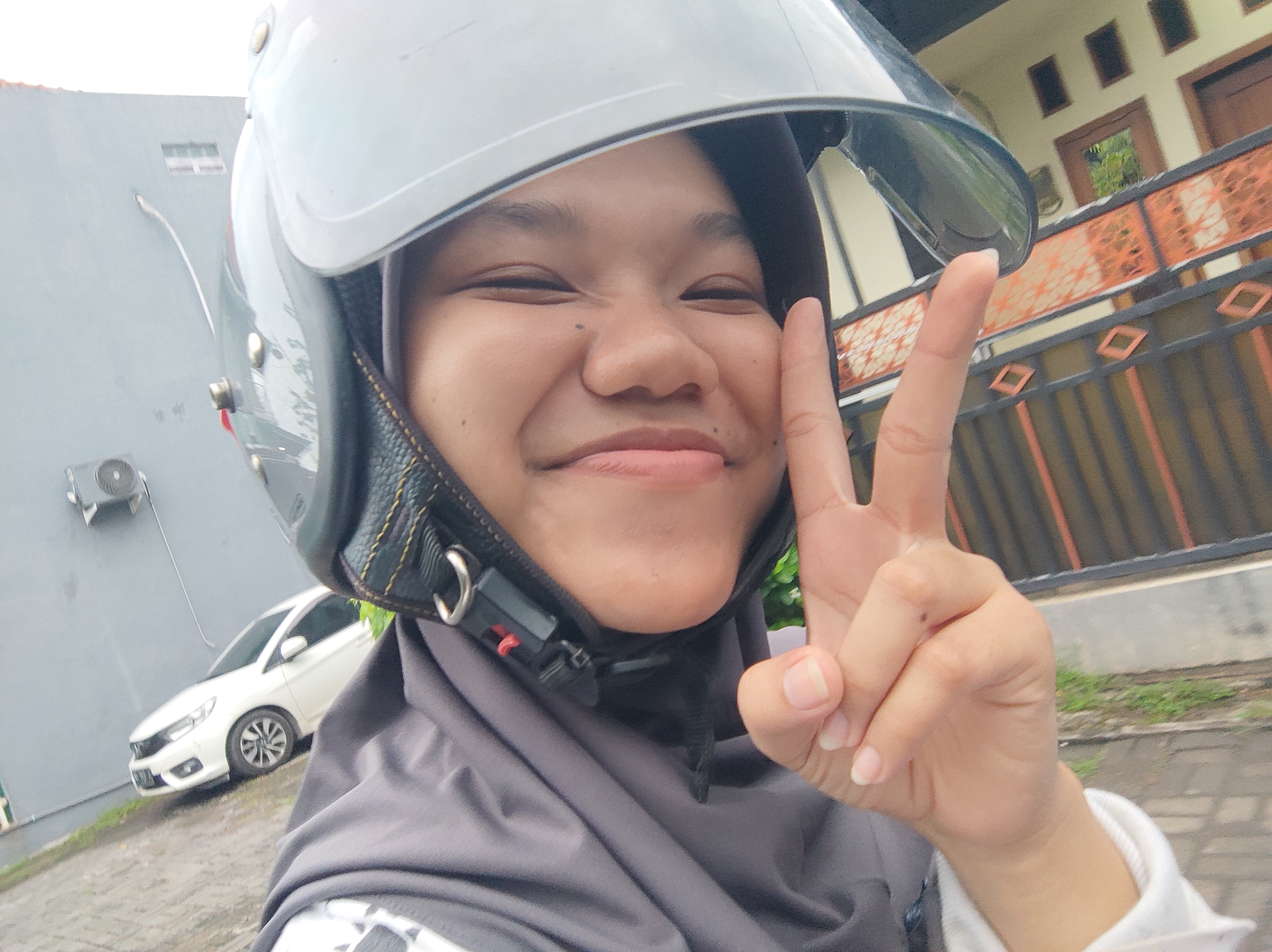 Nabila tersenyum mengenakan helm putih