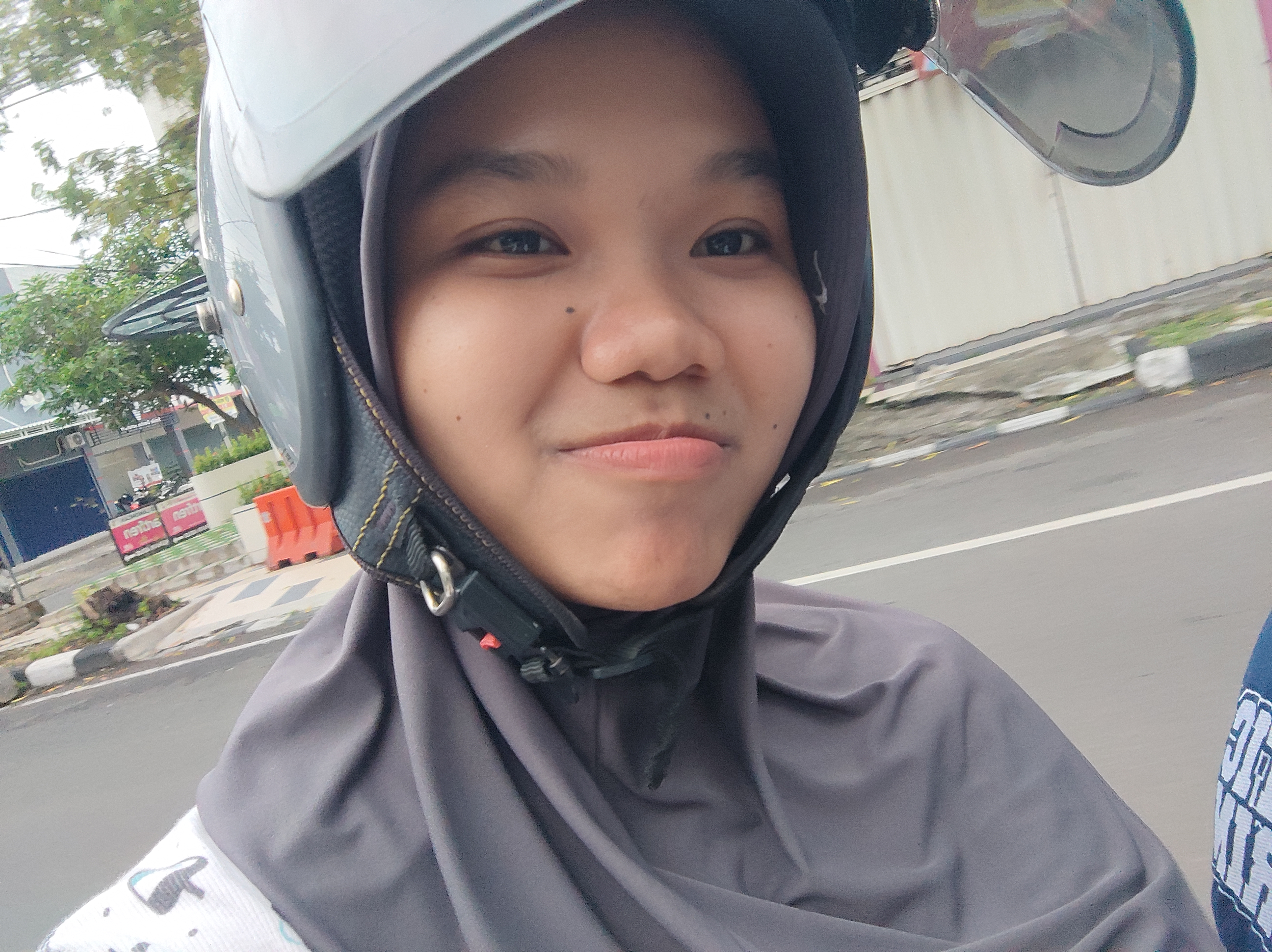 Nabila mengenakan helm di atas motor